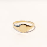 A dainty gold signet ring with a classic oval face.