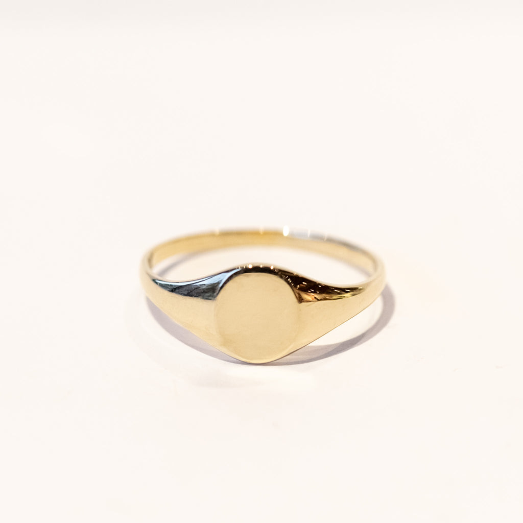 A dainty gold signet ring with a classic oval face.