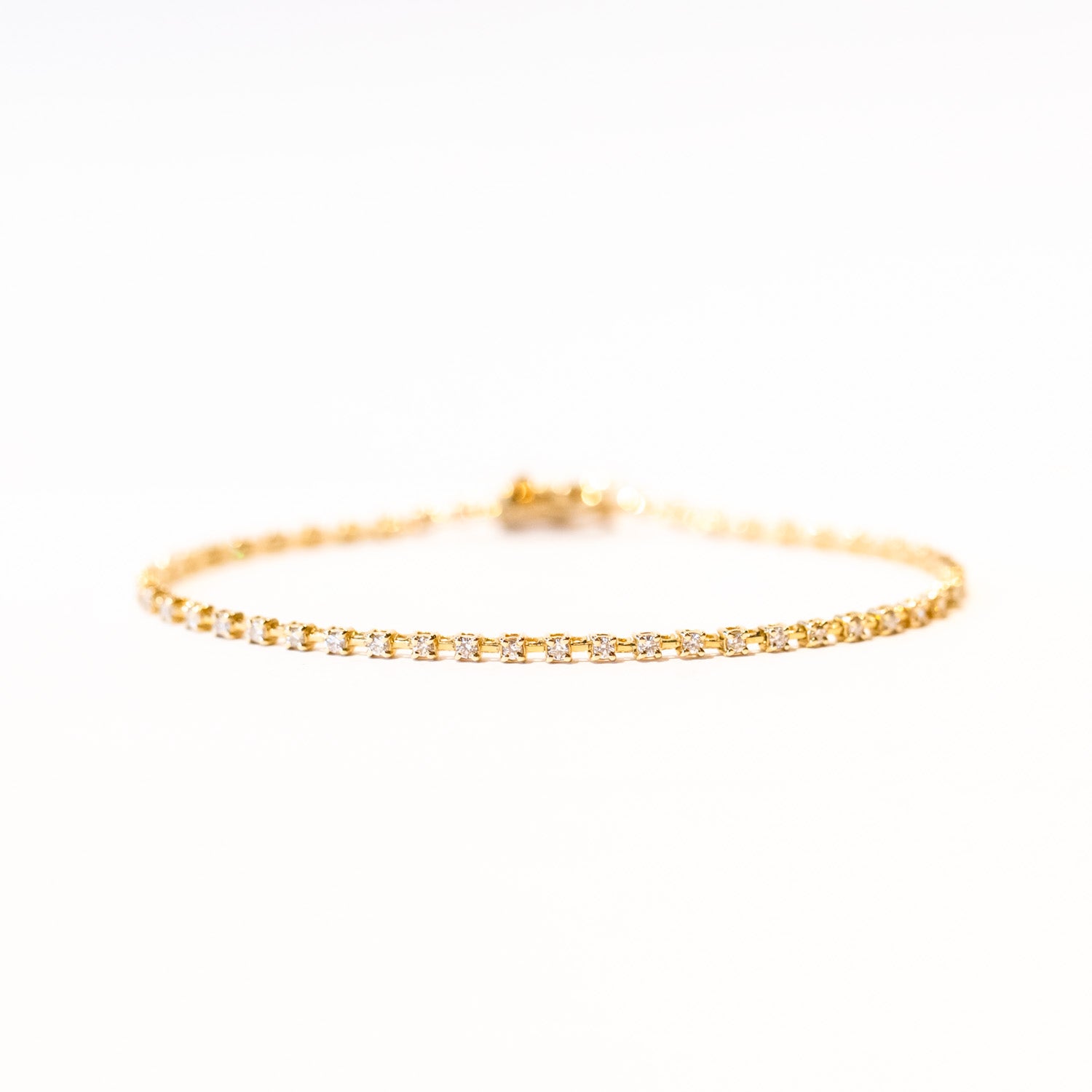 A classic diamond tennis bracelet in yellow gold.