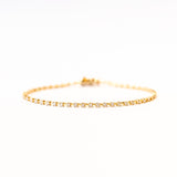 A classic diamond tennis bracelet in yellow gold.