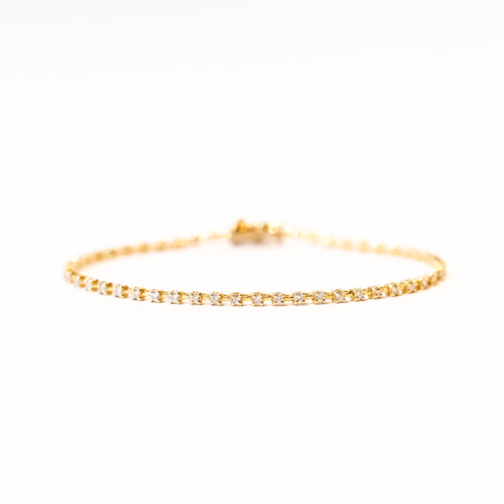 A classic diamond tennis bracelet in yellow gold.