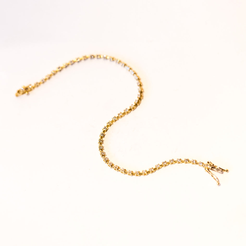 A classic diamond tennis bracelet in yellow gold.