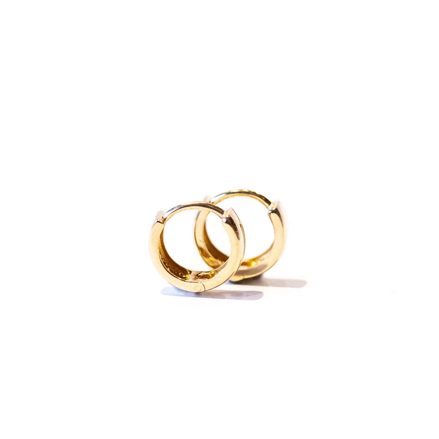 A small, wide gold hoop earring.