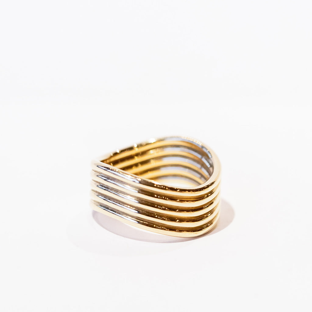 A gold ring made up of five wavy bands soldered together.