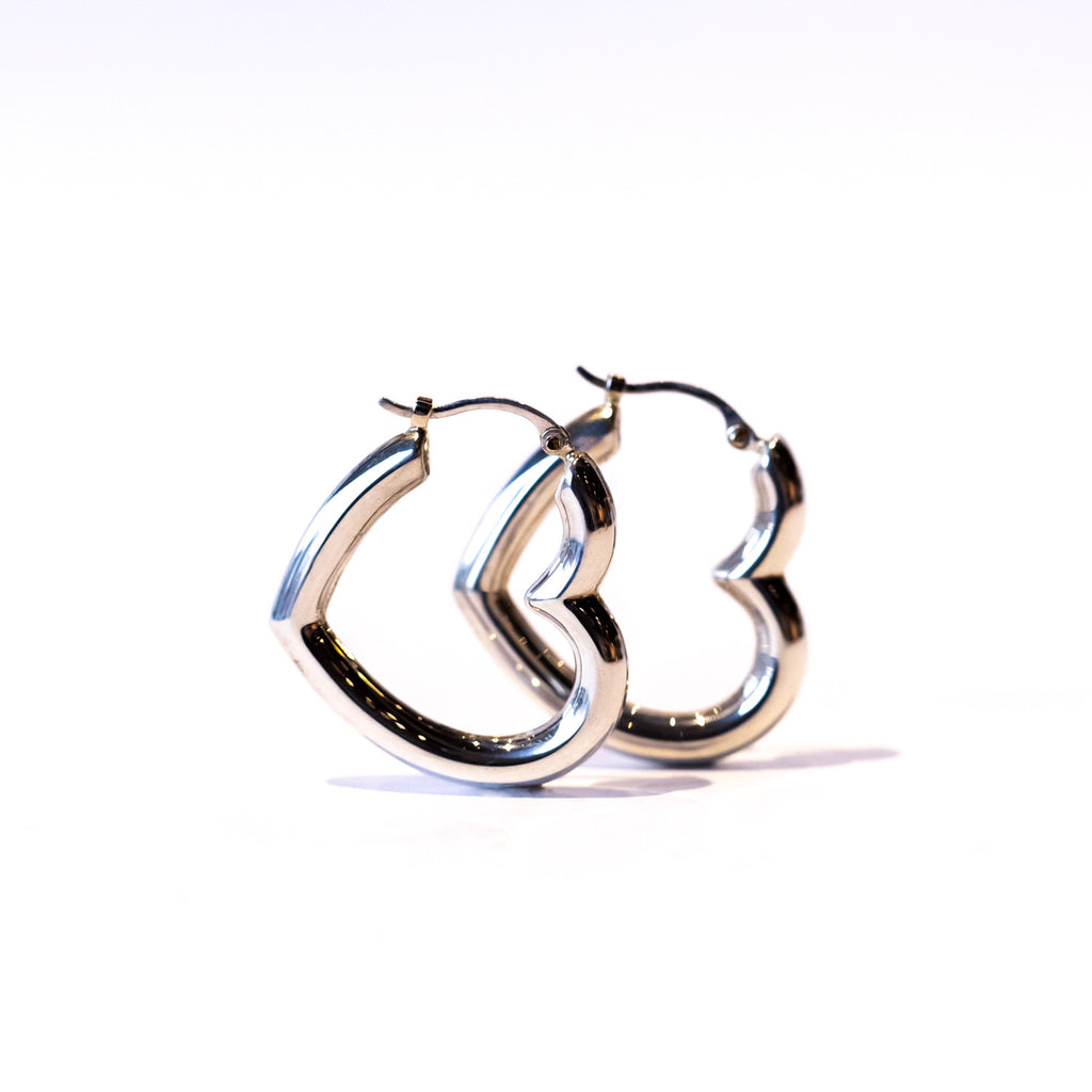 Puffy heart shaped silver hoop earrings.