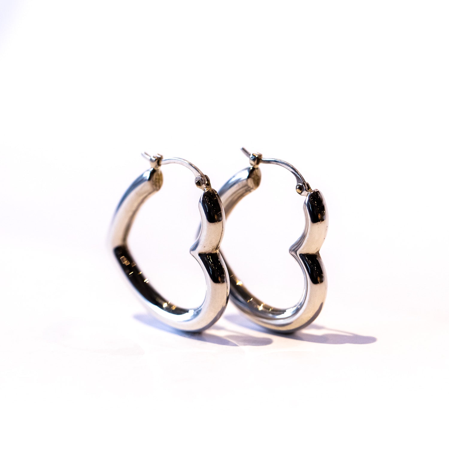 Puffy heart shaped silver hoop earrings.