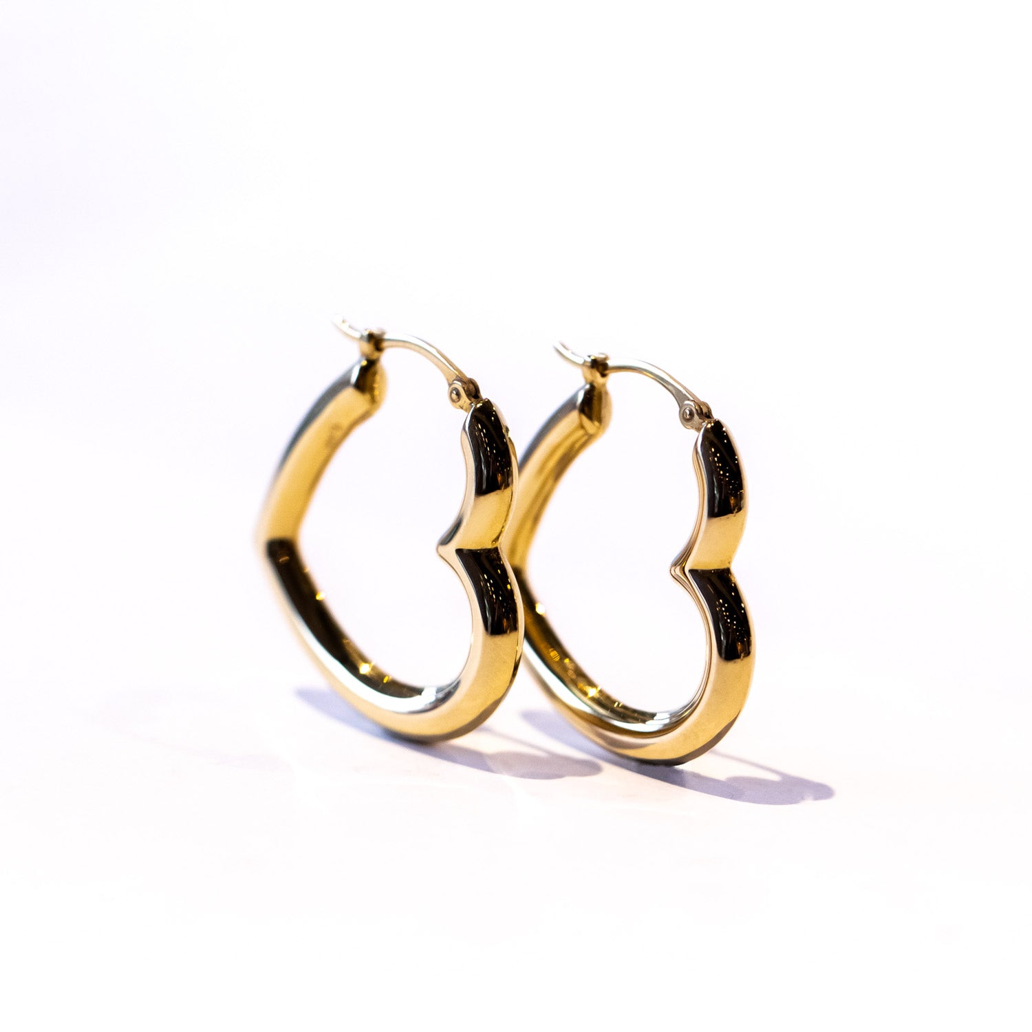 Puffed heart shape gold hoop earrings.
