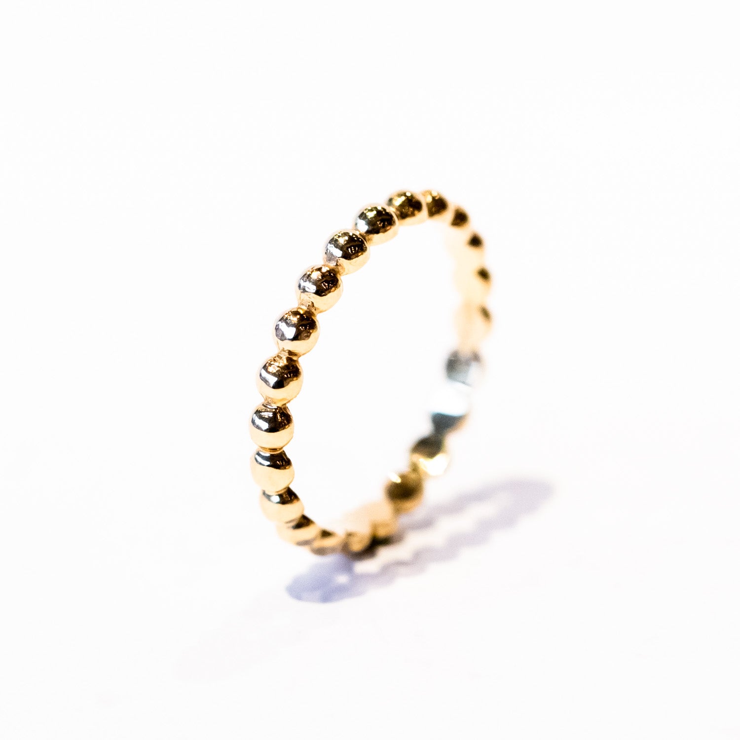 A gold band made up of bubble-shaped balls all the way around.