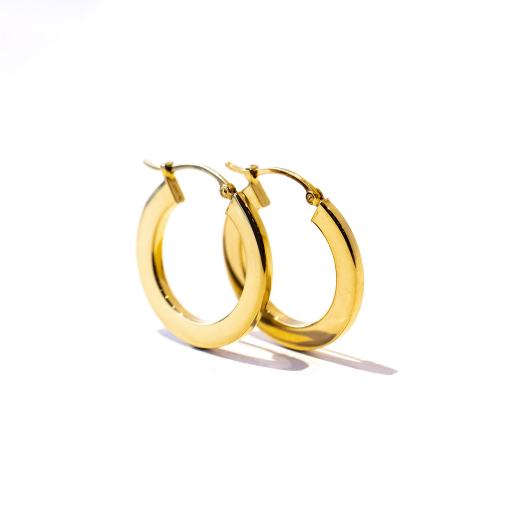 A pair of gold hoop earrings with a flat profile.
