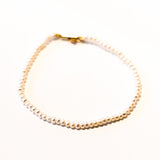 A slim pearl bracelet.