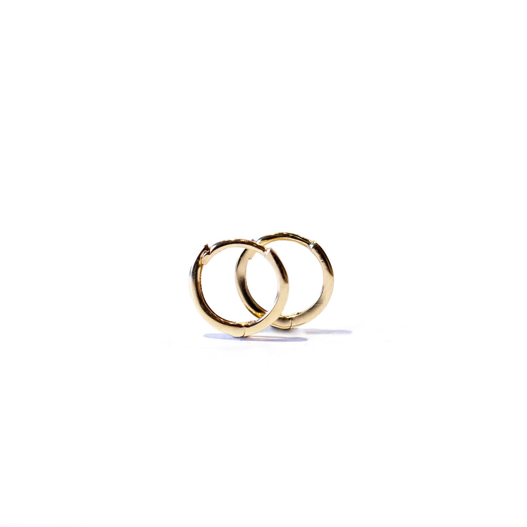 A pair of dainty gold hoop earrings.