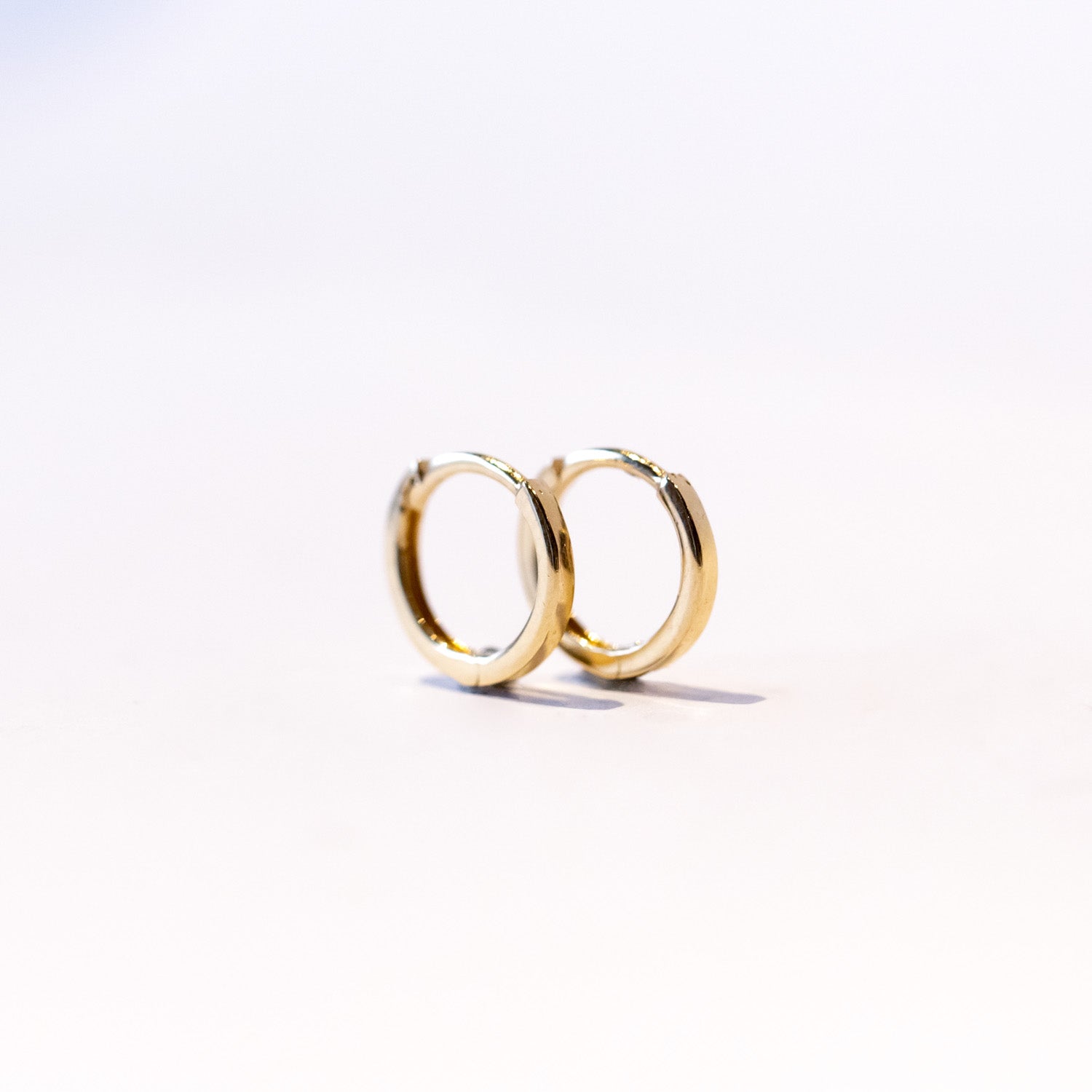 A pair of dainty gold hoop earrings.