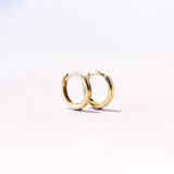 A pair of dainty gold hoop earrings.