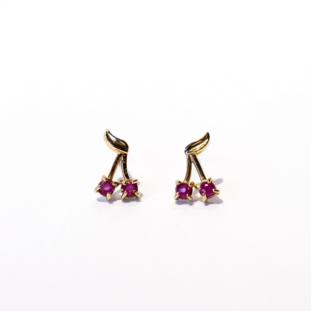 A pair of petite gold stud earrings that look like cherries with rubies for the fruit.