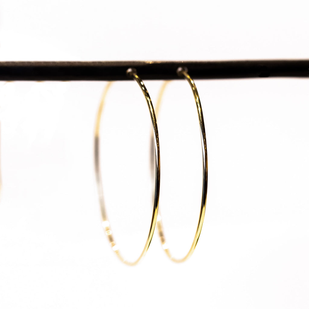 A slim wire endless gold hoop earring.