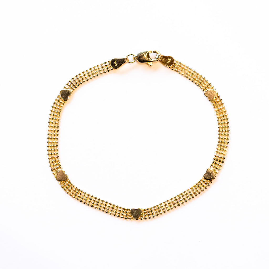 A bracelet made up of four rows of gold bead chain, accented by five gold heart shaped stations.