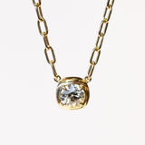 A yellow gold chain necklace of oval links with a prong set diamond on a gold cushion mounting stationed at the center.