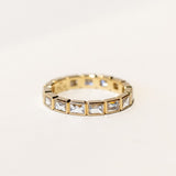 A yellow gold diamond eternity band set with bezel-set french cut diamonds and milgrain edges.