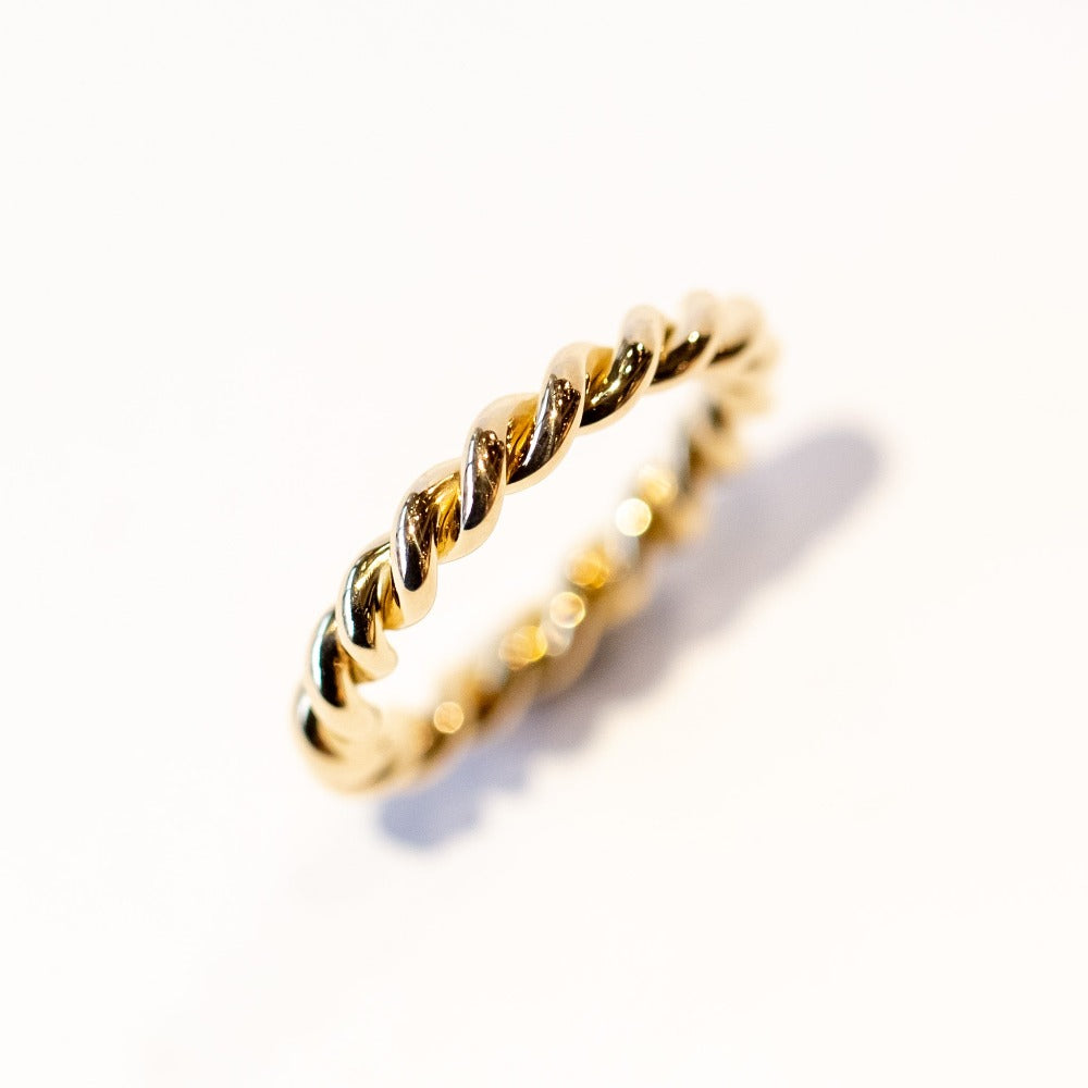 A twist-design yellow gold wedding band.