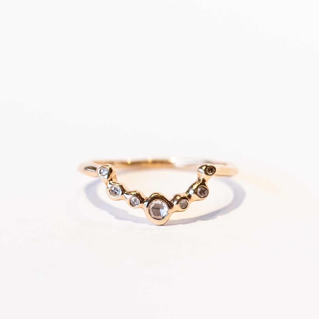 A diamond contour band in 14k rose gold set with rose cut diamonds in organic bezels.