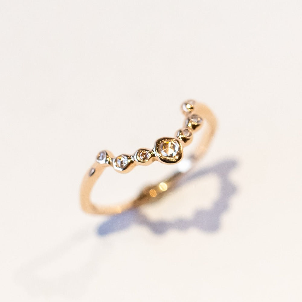 A diamond contour band in 14k rose gold set with rose cut diamonds in organic bezels.