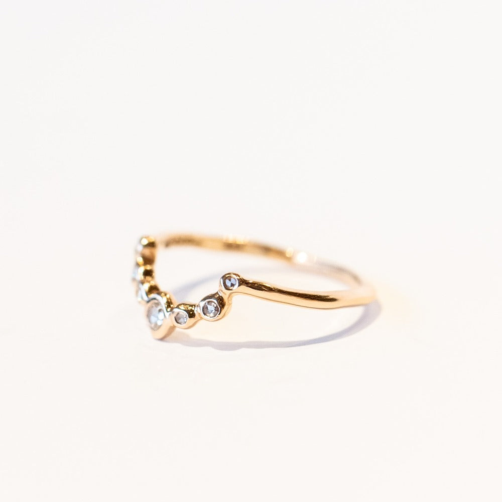 A diamond contour band in 14k rose gold set with rose cut diamonds in organic bezels.