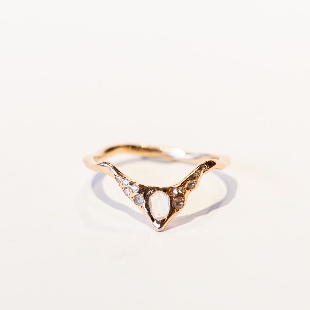 A rose gold, peaked contour band with a white moonstone and sparkling diamond accents.
