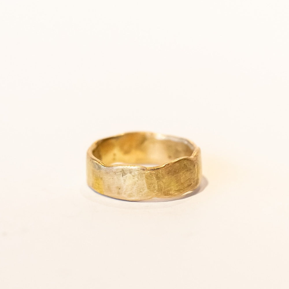 An organic yellow gold wide wedding band.