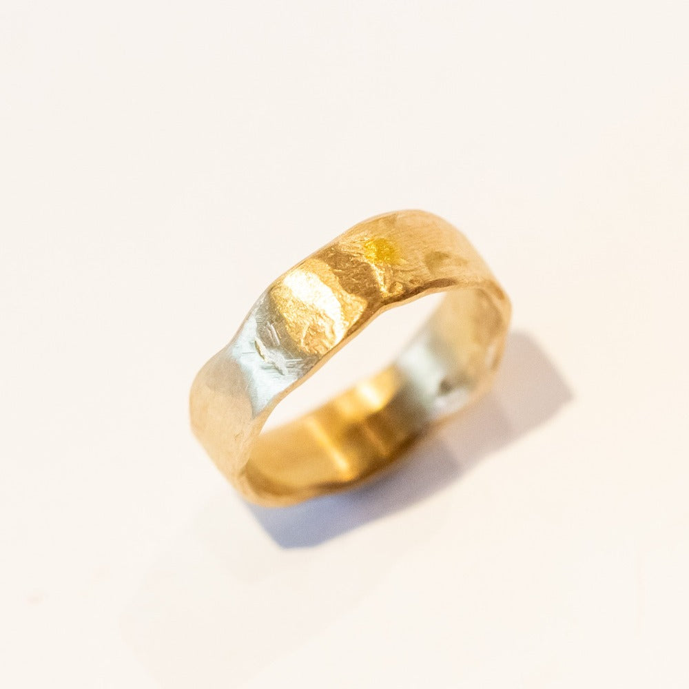 An organic yellow gold wide wedding band.