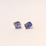 Asymmetrical, rough faceted tanzanite stud earrings in yellow gold.