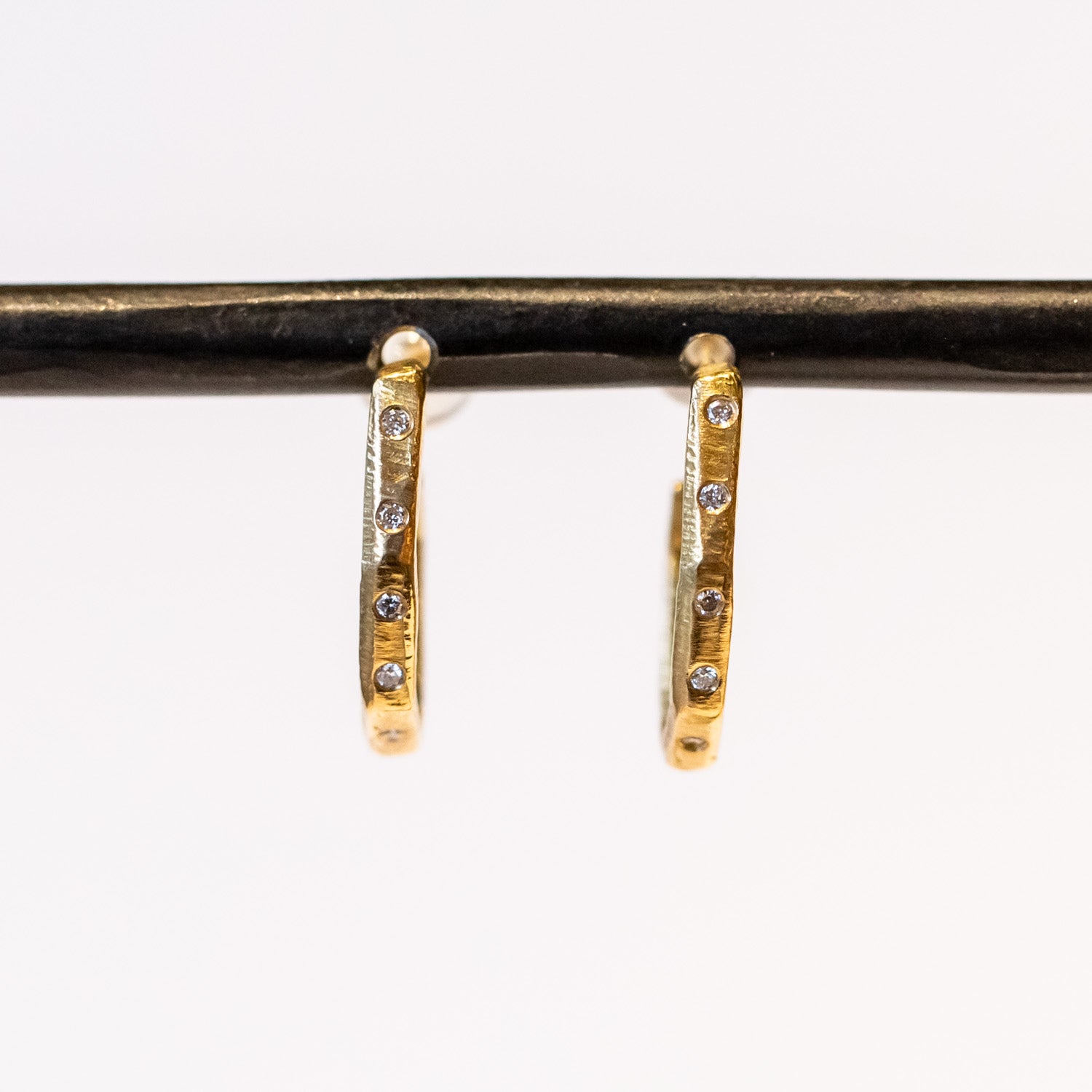 Textured yellow gold hoop earrings set with small diamonds down the front.