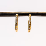 Textured yellow gold hoop earrings set with small diamonds down the front.