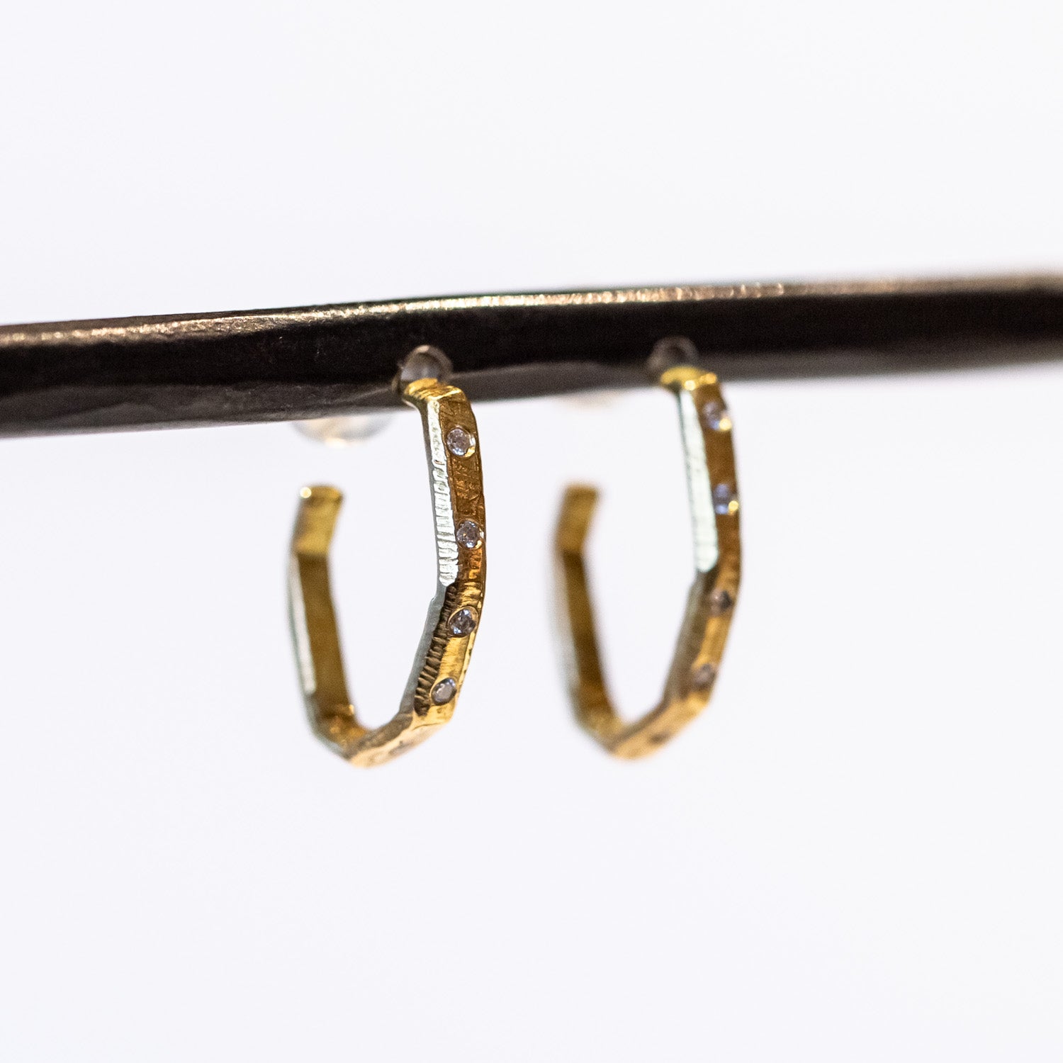 Textured yellow gold hoop earrings set with small diamonds down the front.