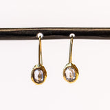 Yellow gold drop earrings with oval blue sapphires set in textured bezels.