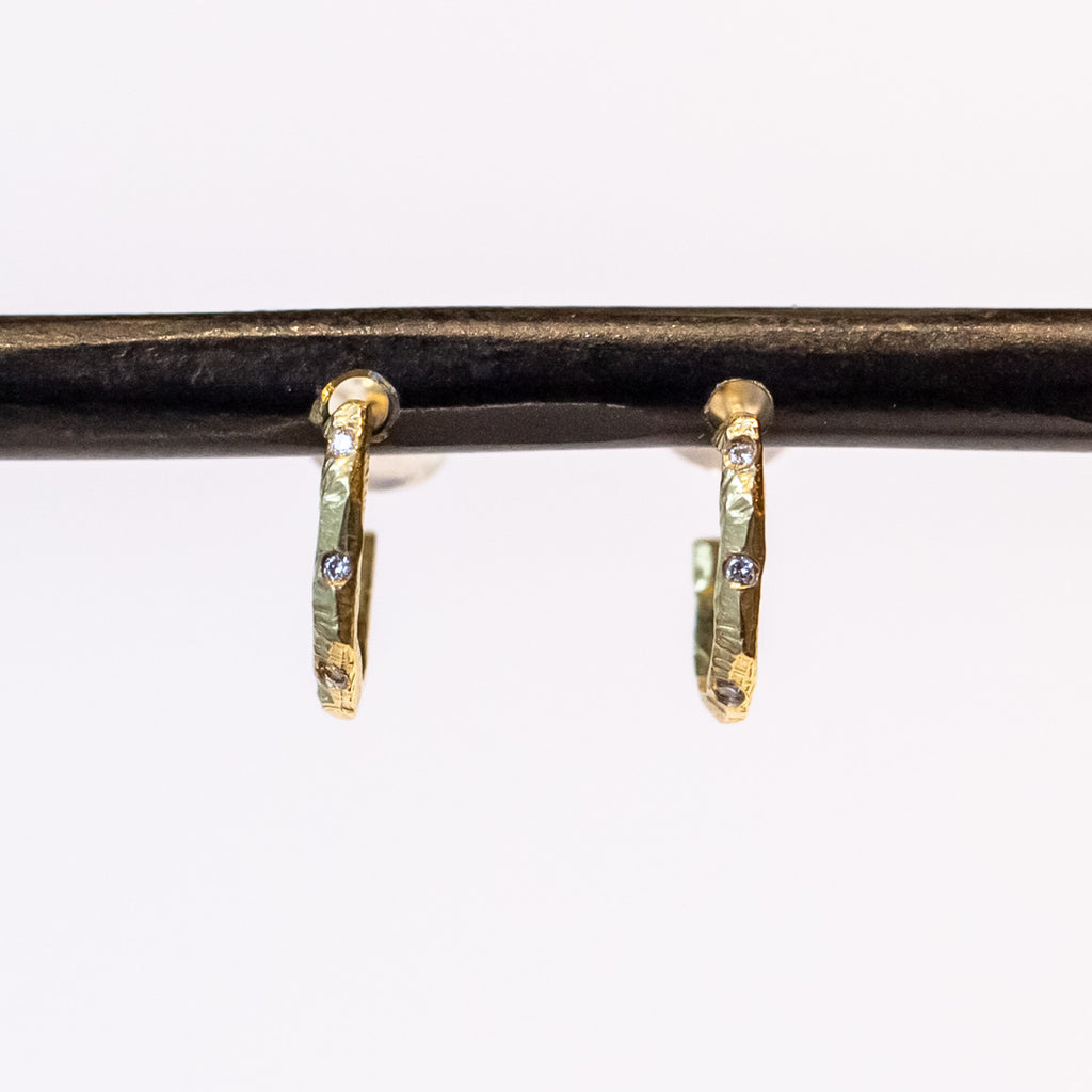Small, textured yellow gold hoop earrings with three small diamonds along the front.