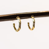 Small, textured yellow gold hoop earrings with three small diamonds along the front.