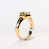 A chunky gold solitaire engagement ring featuring an old mine European cut diamond prong set into a cushion-like setting.