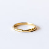 A carved-texture, slim yellow gold band.