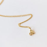 A letter "A" gold pendant with a snake making up the letter, hanging on a cable chain necklace.