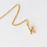 A snake forms the letter K in this gold initial pendant hung from a classic cable chain.