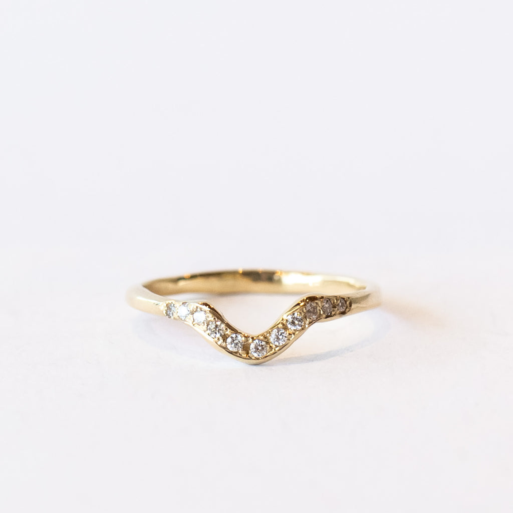 Thin yellow gold contour band with diamonds on the top.
