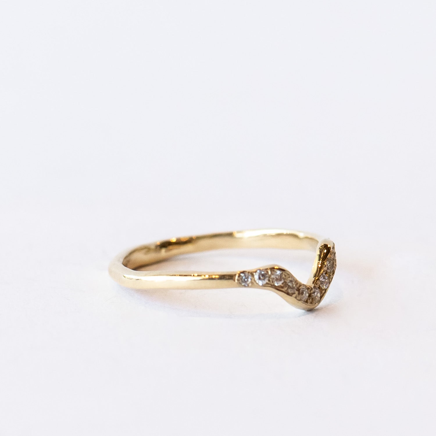 Thin yellow gold contour band with diamonds on the top.