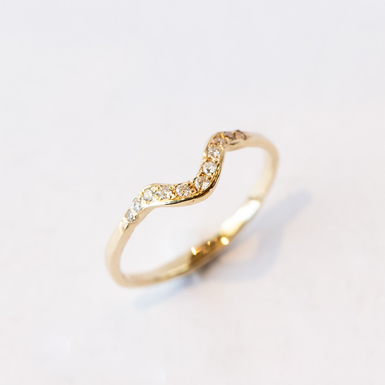 Thin yellow gold contour band with diamonds on the top.