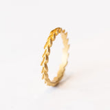 A carved laurel leaf pattern yellow gold wedding band.