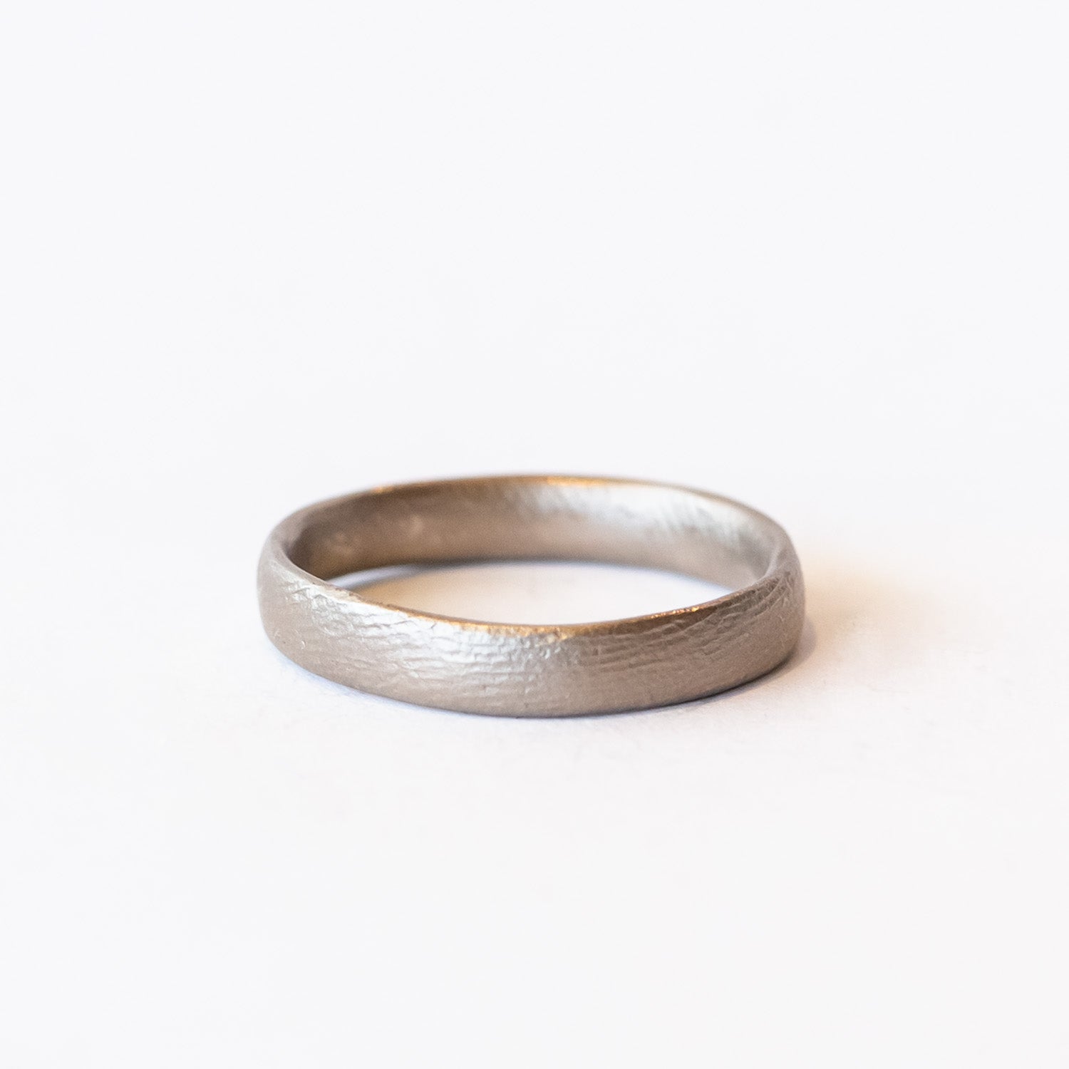 A contemporary men's wedding band with rounded edge in a lightly textured matte finish.