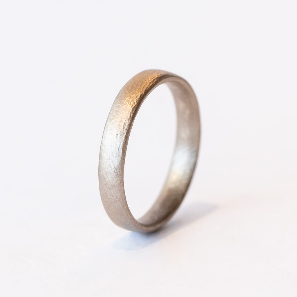 A contemporary men's wedding band with rounded edge in a lightly textured matte finish.