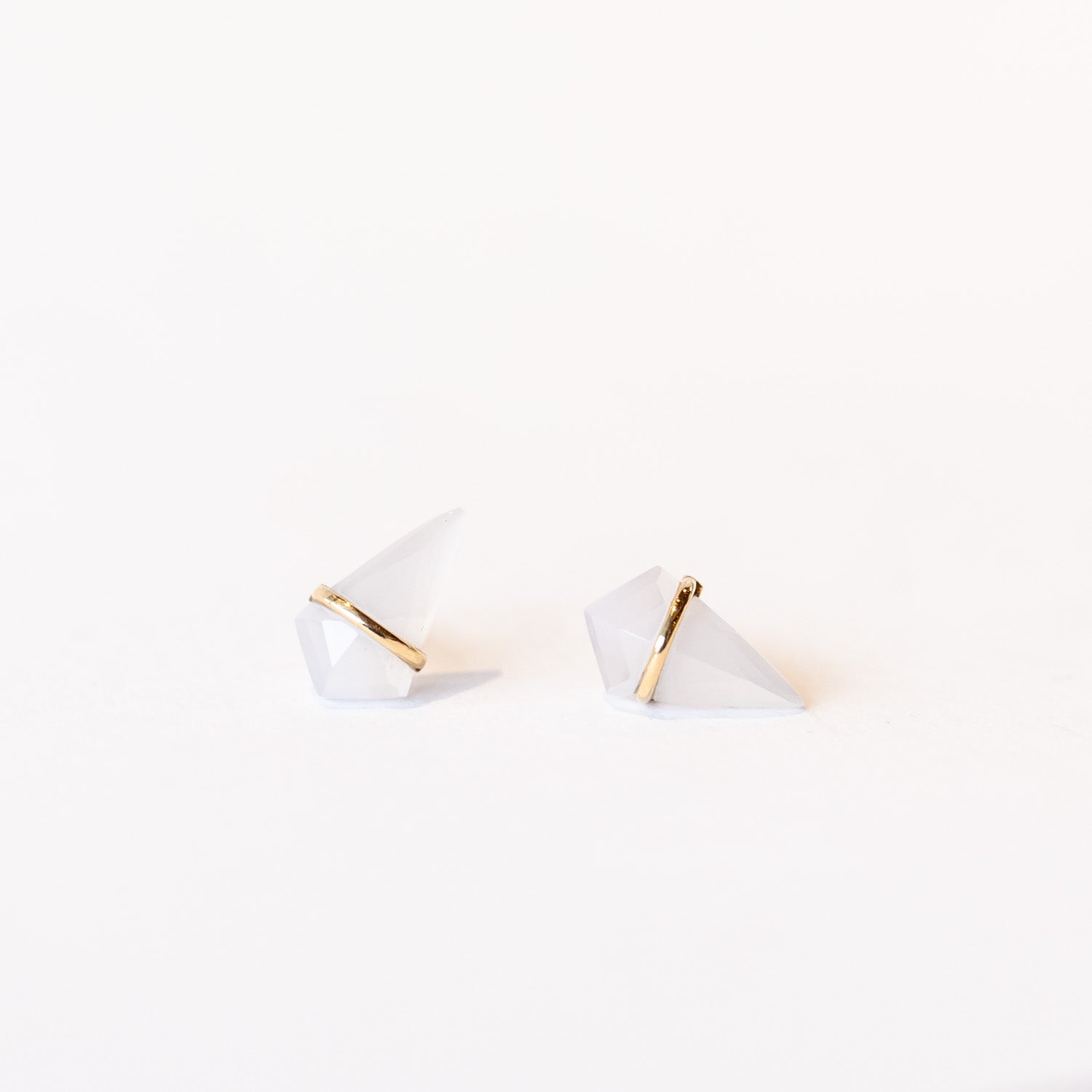 Stud earrings featuring kite-shaped chalcedony stones wrapped in a slender band of yellow gold.