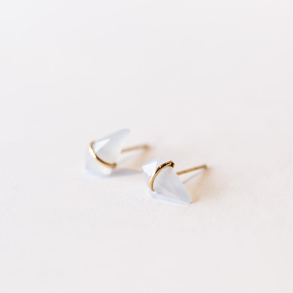Stud earrings featuring kite-shaped chalcedony stones wrapped in a slender band of yellow gold.