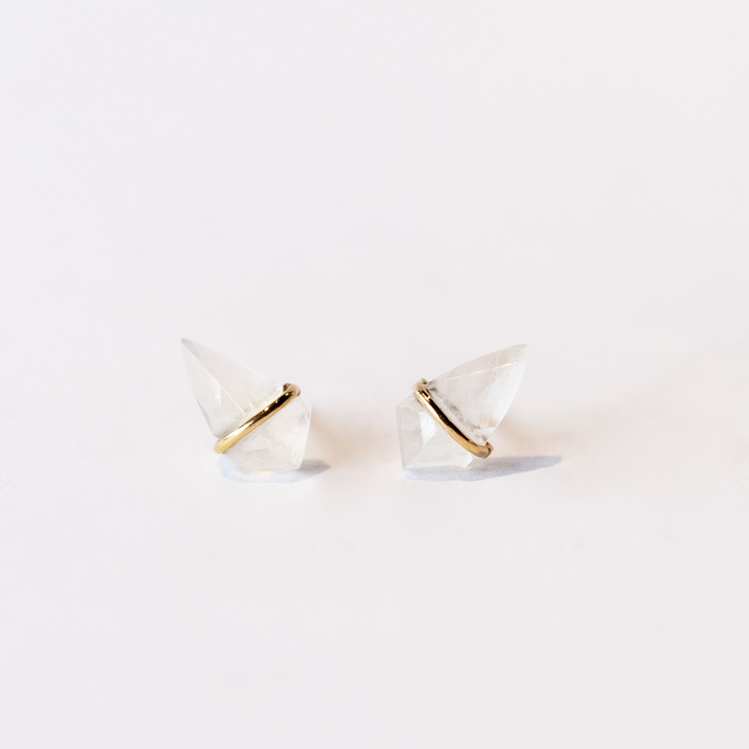 Stud earrings featuring kite-shaped moonstone gems wrapped in a band of yellow gold.