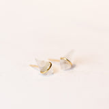 Stud earrings featuring kite-shaped moonstone gems wrapped in a band of yellow gold.